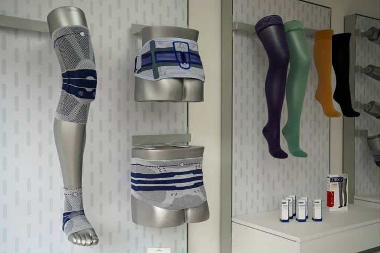 Bandagen und Kompressionsstrümpfe, die an der Wand drapiert sind.