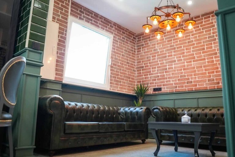 Barbarossa Barbershop Wartebereich mit schwarzen Ledersofas