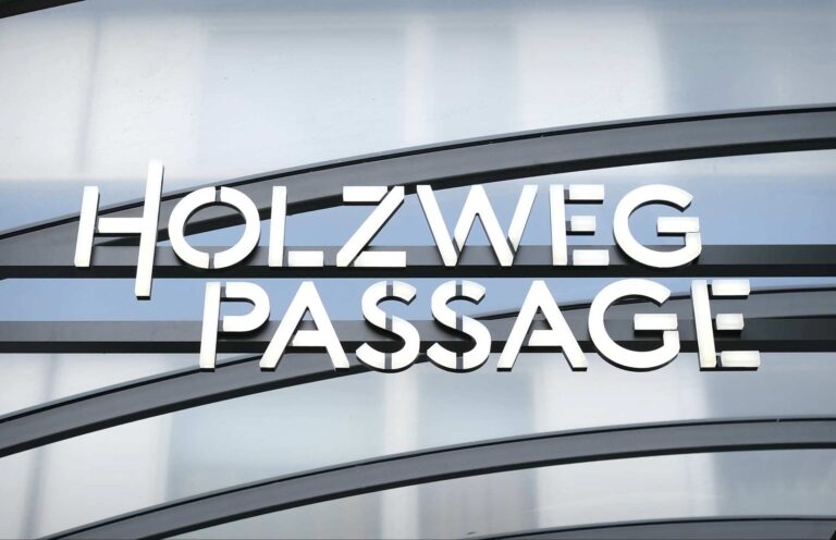 Außenbeleuchtung des Logos der Holzweg-Passage vor der Unterführung